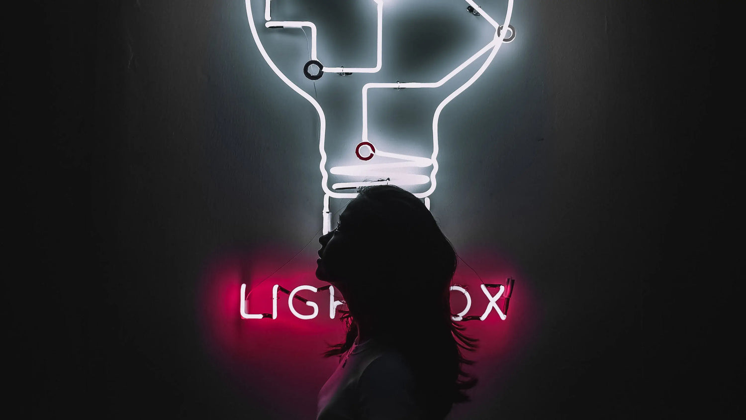 woman looking up in the neon bulb