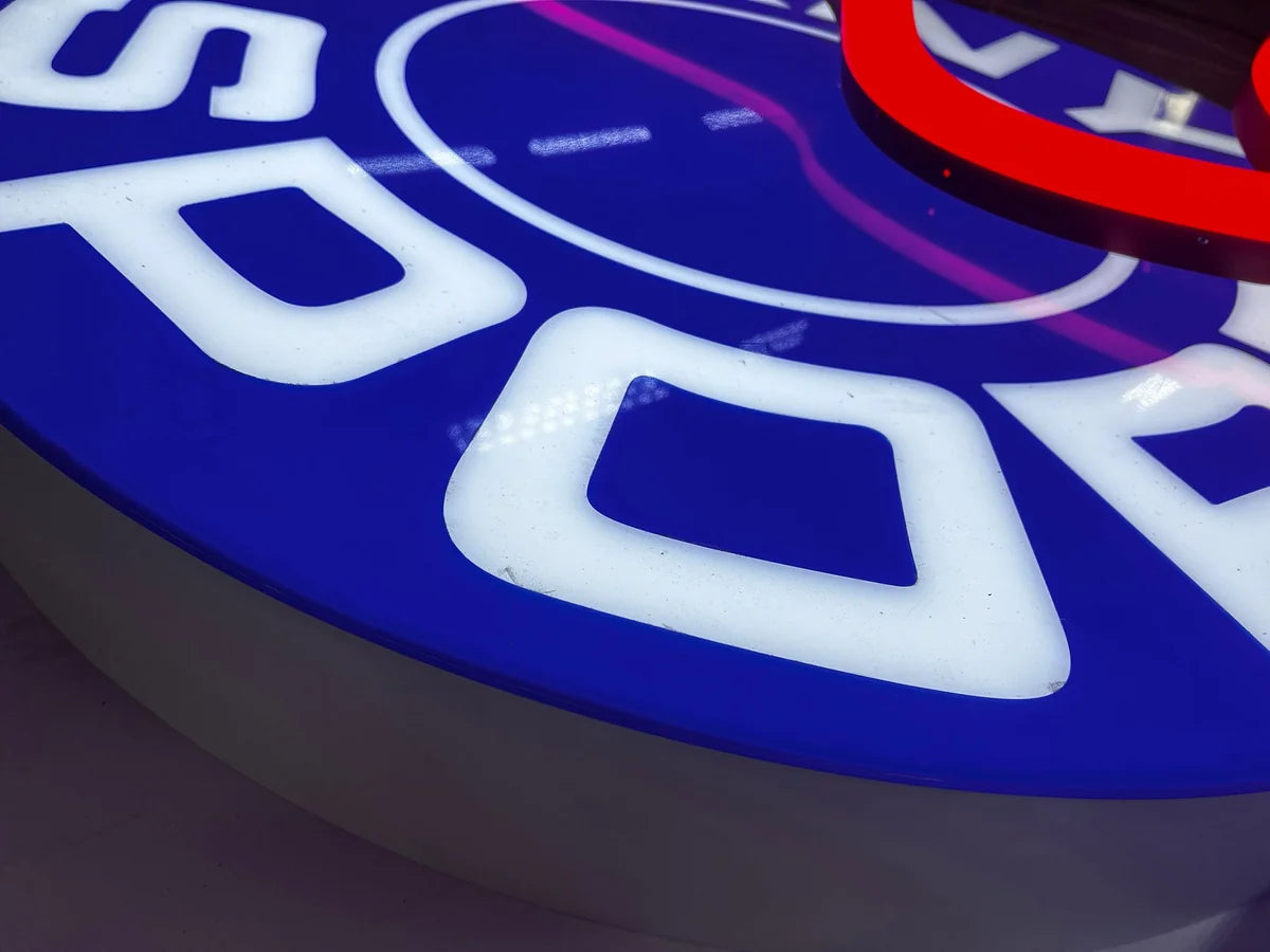 Close-up of the illuminated Dany Sport logo with white letters on a blue background.