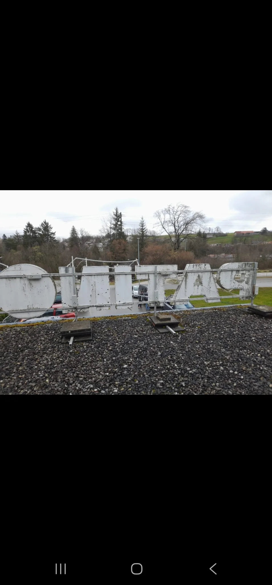 Rear of the original PATINOIRE sign and its metal structure before replacement.