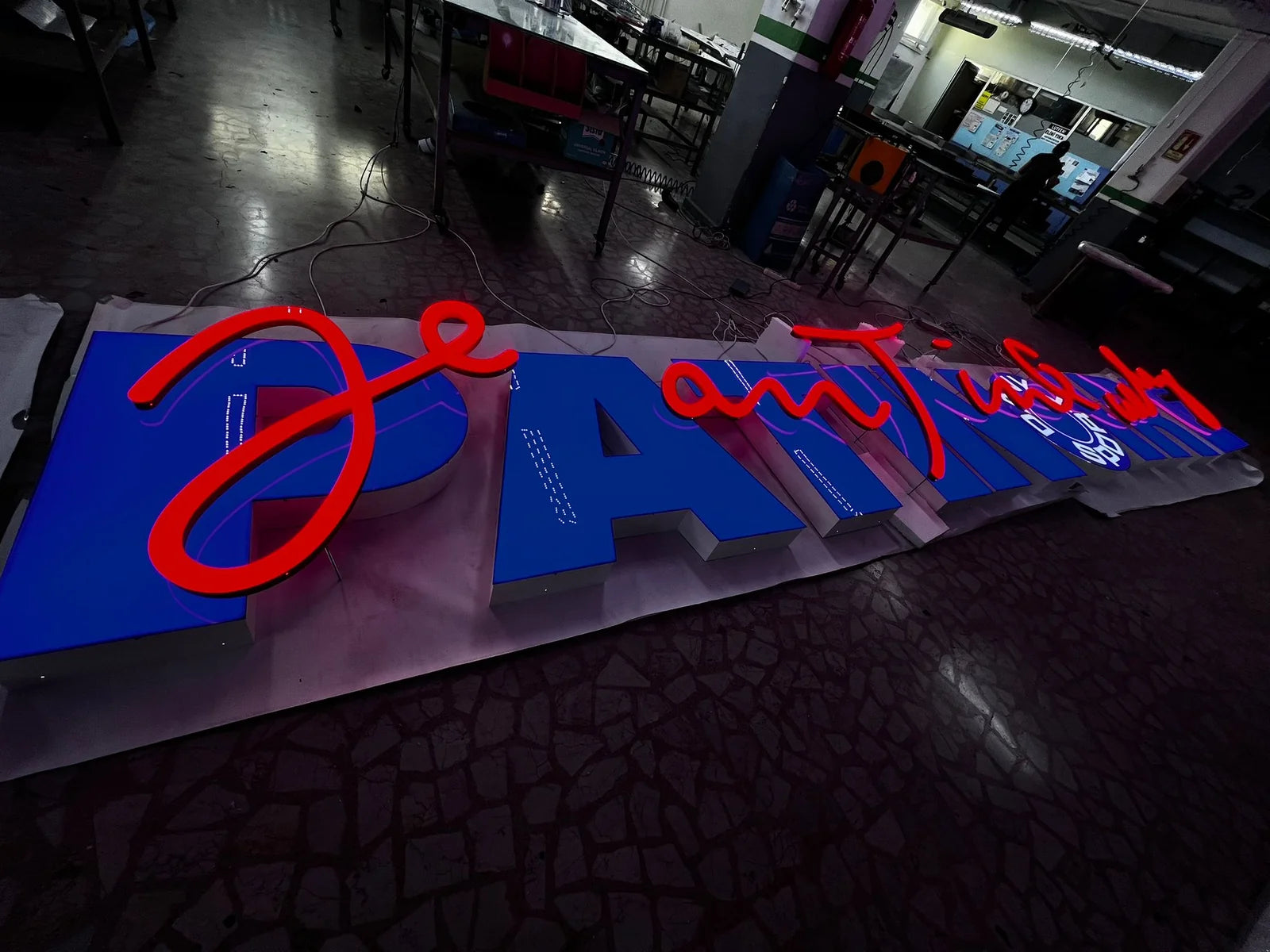The PATINOIRE sign and red Jean Tinguely script fully assembled and illuminated in the workshop.