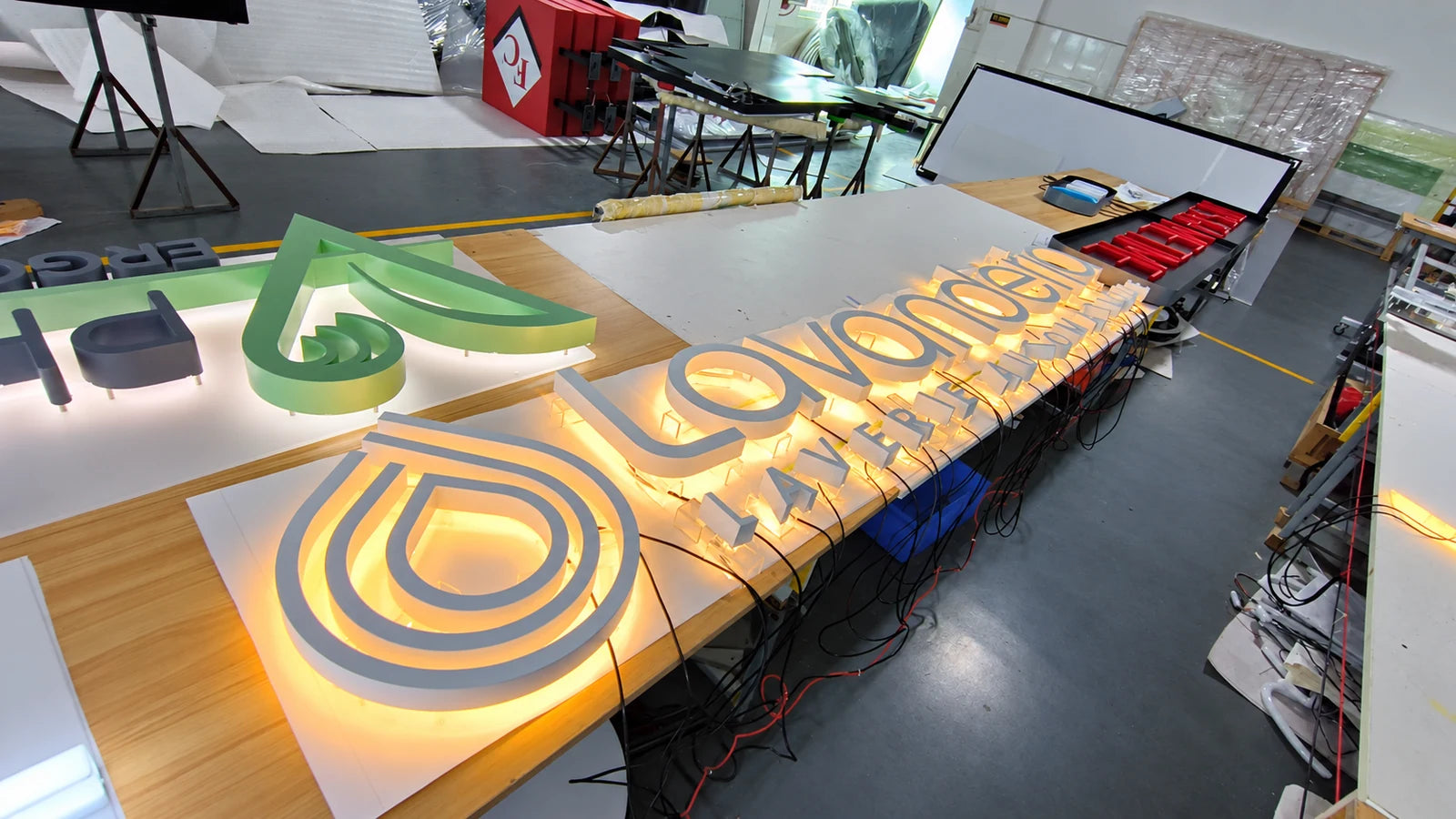 Gesamtansicht der eingeschalteten Lavanderia-Buchstaben und des Logos in der Werkstatt.
