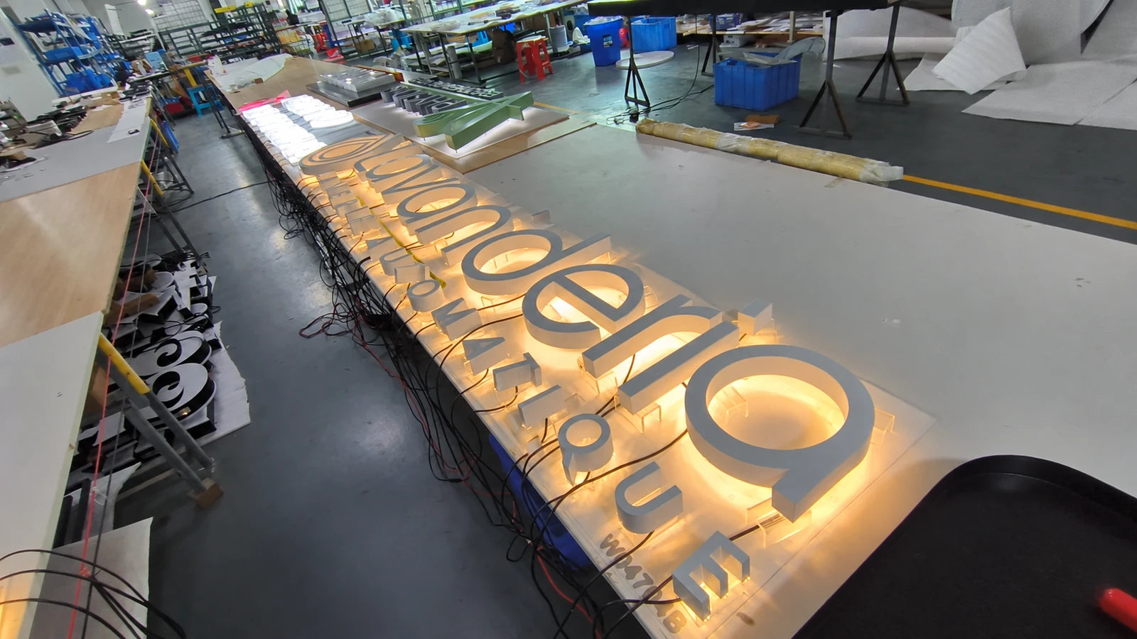 Eingeschalteter Lavanderia-Schriftzug in der Werkstatt mit Hinterleuchtung um die weissen Buchstaben.