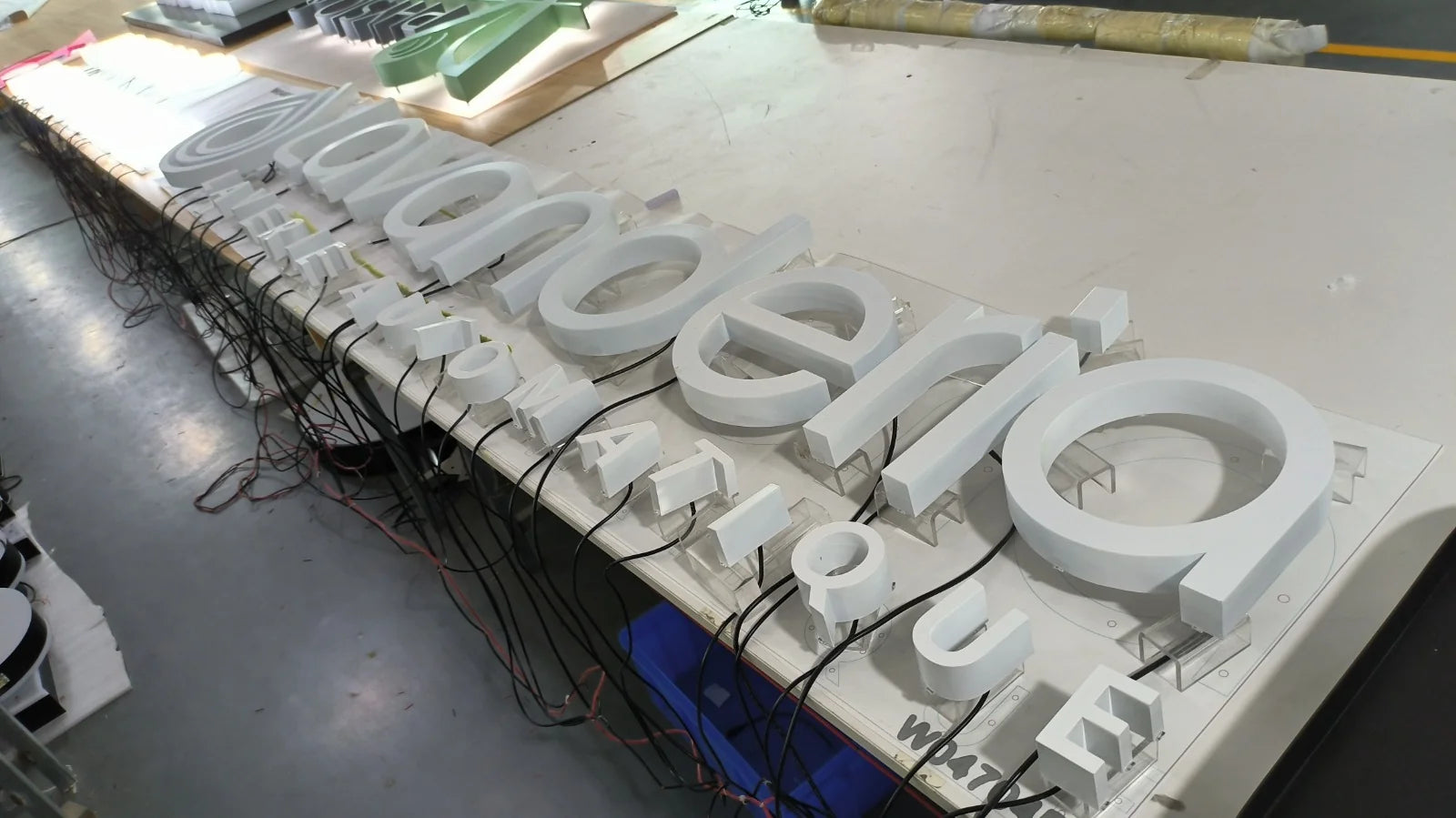 Weisse Lavanderia-3D-Buchstaben in der Werkstatt, ohne Beleuchtung angeordnet.