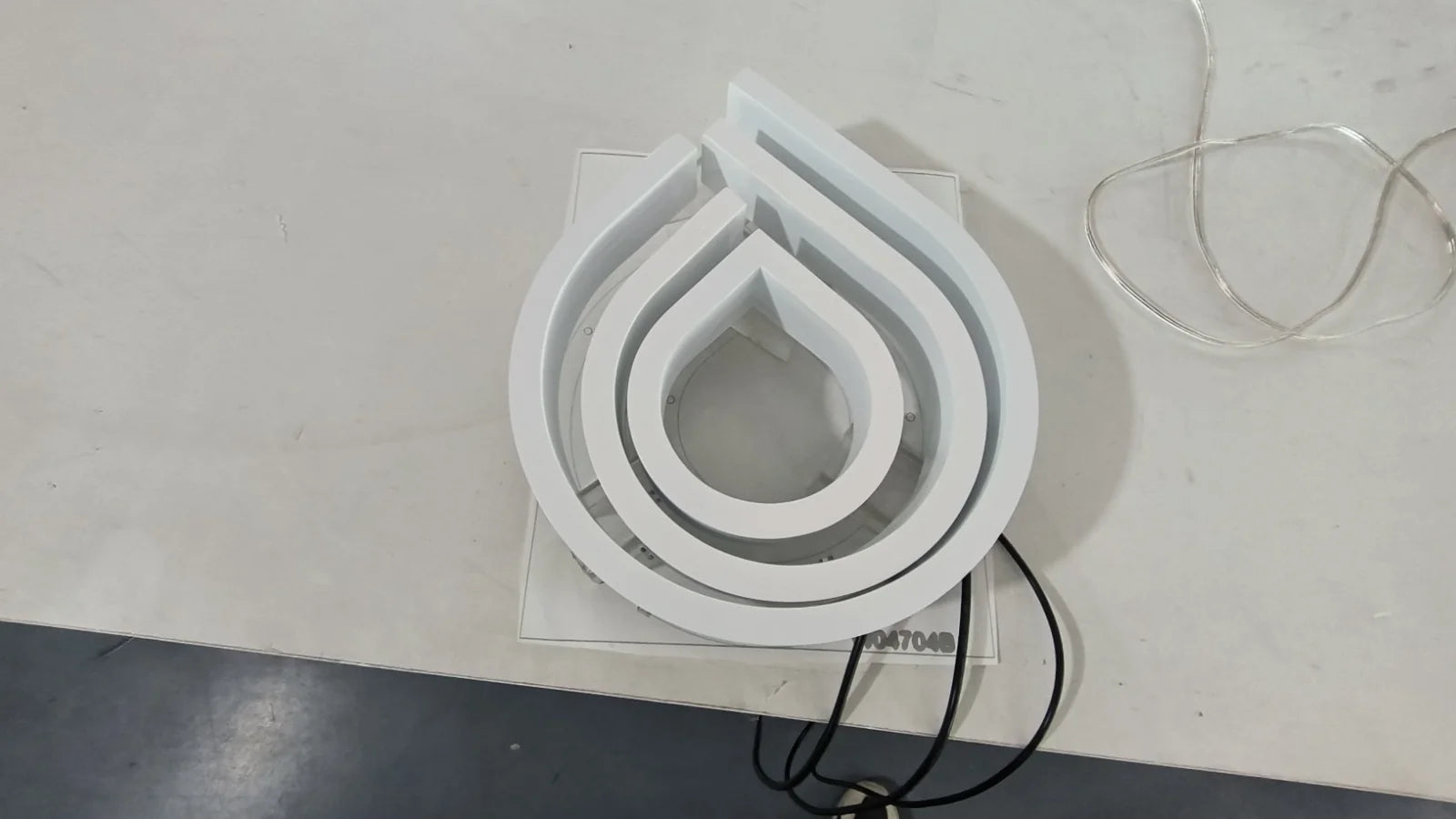 Weisses Lavanderia-Logo als Reliefelement in der Werkstatt, ohne Beleuchtung.