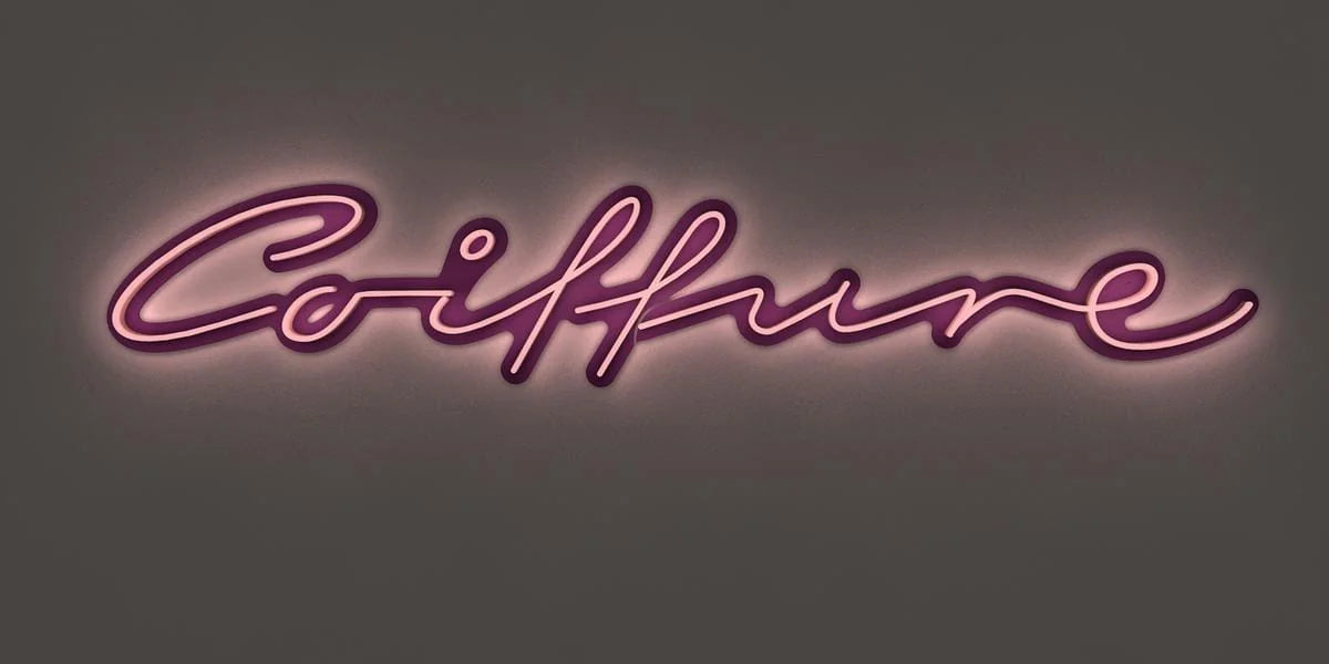 Entwurfsvisualisierung der Coiffure-Leuchtschrift von vorne, mit heller Leuchtschrift und magentafarbenem Hintergrund vor einer dunklen Fläche.