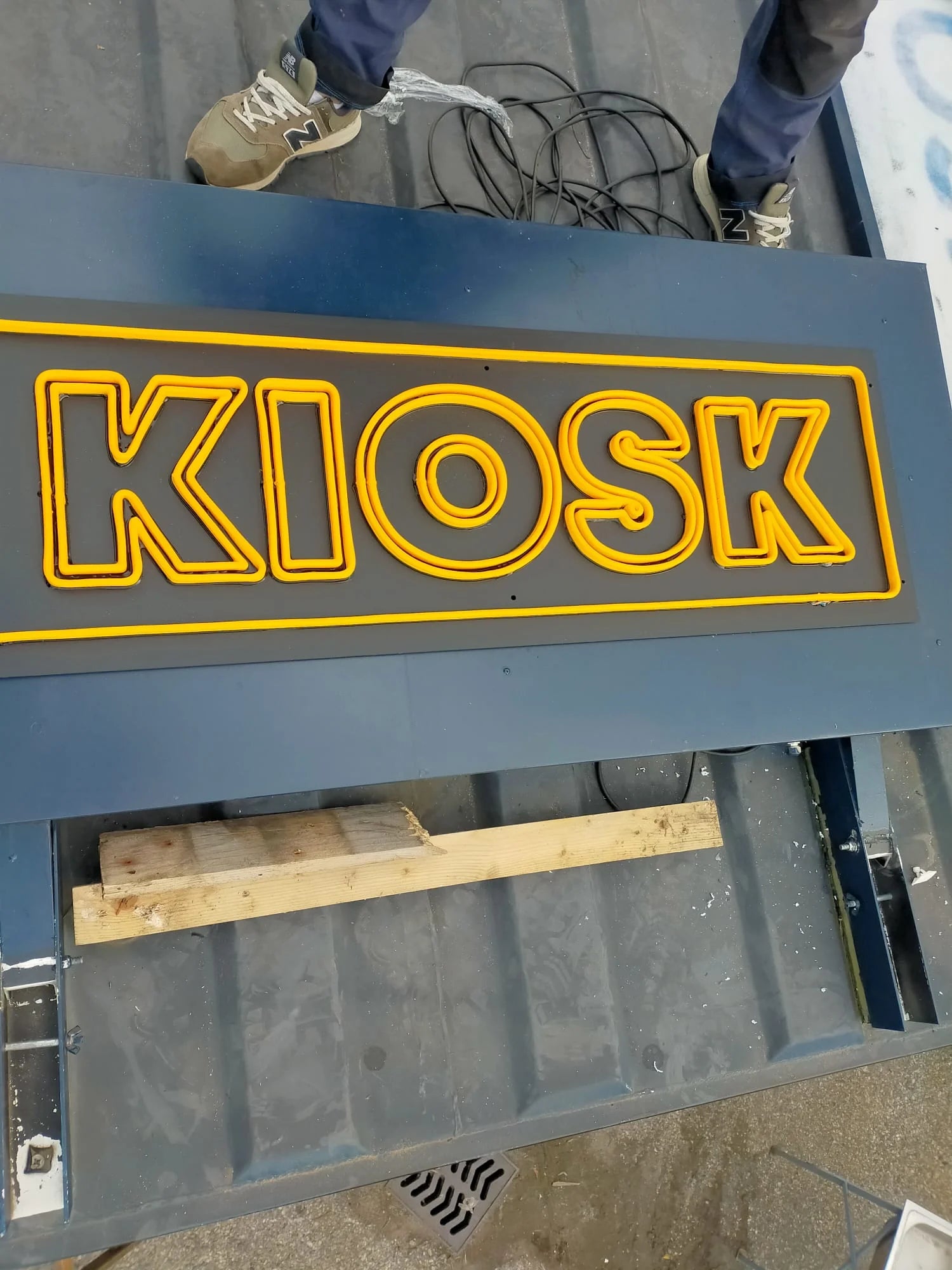 Vorbereitung des KIOSK-Schilds und seiner Kabel auf einer dunklen Konstruktion am Montageort in Montreux.