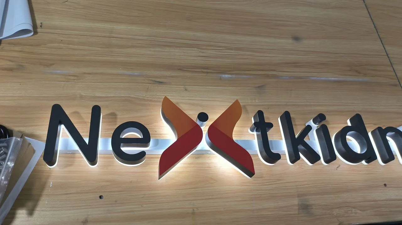 Detail of the raised Nextkidney logo during workshop lighting tests, showing its colour and light spreading behind the element.